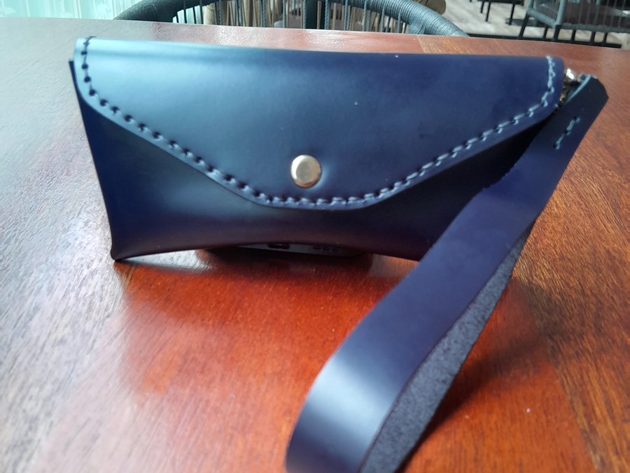 Navy leather eyewear case with stitched flap and wrist strap